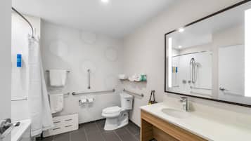 A modern bathroom with a toilet, sink, and shower.
