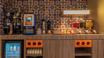 A coffee station with multiple coffee machines, a beverage dispenser, and a refrigerated display.