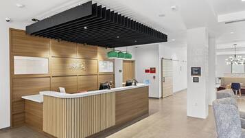 Un comptoir d’accueil moderne avec un revêtement en bois et un panneau supérieur noir.