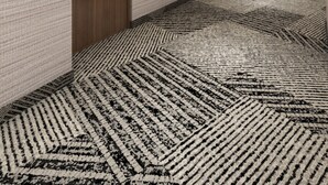 A hotel hallway with a patterned carpet, wooden doors, and recessed lighting. - Homewood Suites By Hilton Saltillo (Saltillo)