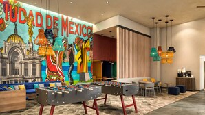 A lobby with a foosball table, colorful artwork, and a seating area with sofas and chairs. - Homewood Suites By Hilton Saltillo (Saltillo)