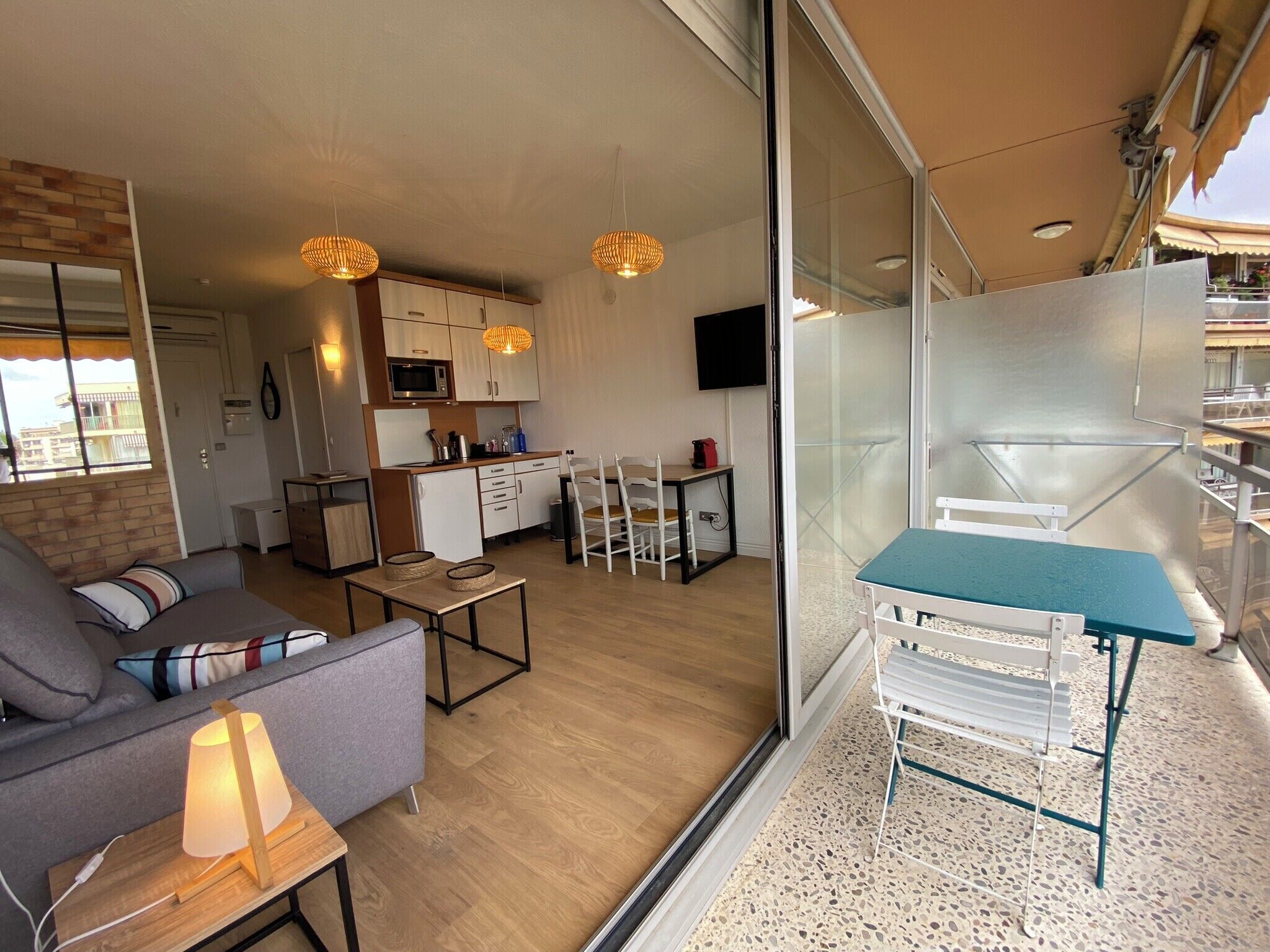 A modern apartment with a living room, kitchen, and balcony.