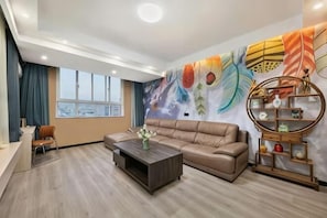 A modern living room with a sofa, coffee table, and decorative wall art. - Xunxian Guest House (Hebi Xunxian Ancient City Branch) (Xun County)