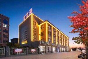 Un hotel con un letrero llamativo, varios pisos y una fachada bien iluminada.