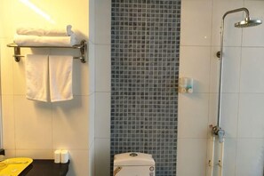 A bathroom with a shower, a towel rack with towels, a toilet, and a sink with toiletries. - Xunxian Guest House (Hebi Xunxian Ancient City Branch) (Xun County)
