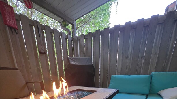 A covered outdoor seating area with a fire feature and a grill. - Modern/Retro 1br Condo by Exceptional Stays (High Point)