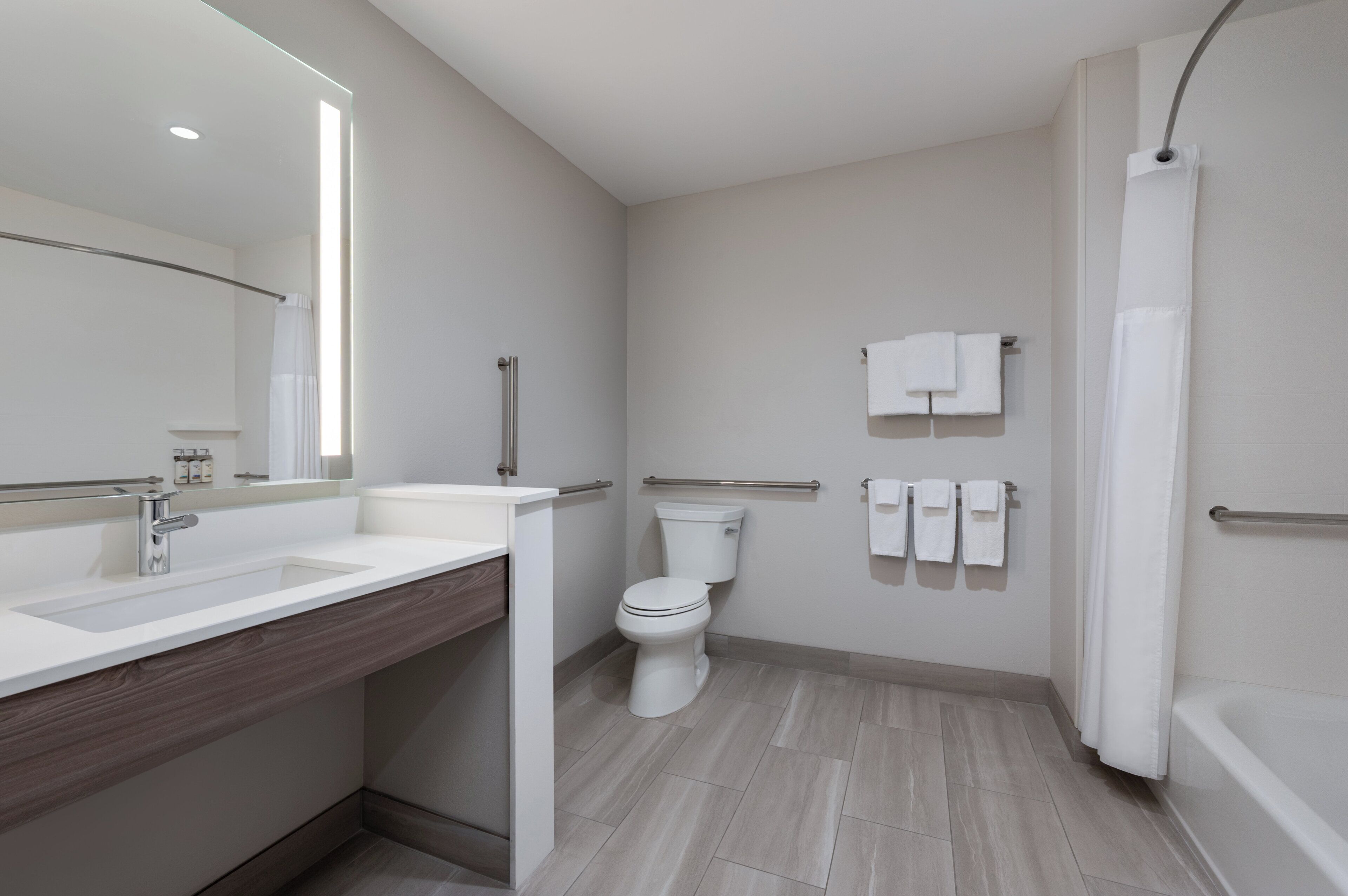 A modern bathroom with a large sink, toilet, and bathtub.