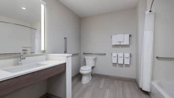 A modern bathroom with a large sink, toilet, and bathtub.