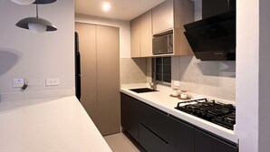 A modern kitchen with a white countertop, black cabinets, a built-in microwave, and a gas stove. - Relax in Flandes Tolima, apartment with Swimming Pool (Flandes)