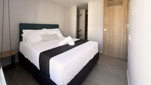 A modern hotel room with a neatly made bed, a wooden door, and a built-in wardrobe. - Relax in Flandes Tolima, apartment with Swimming Pool (Flandes)