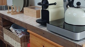 A kitchen with a wooden countertop, a kettle, a toaster, and a dish rack. - Rose's Glamping (Rincón de la Victoria)