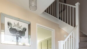 A staircase with white railings leading to a second floor. - Spacious 3-Bedroom Home in Basildon, Essex London (Basildon)