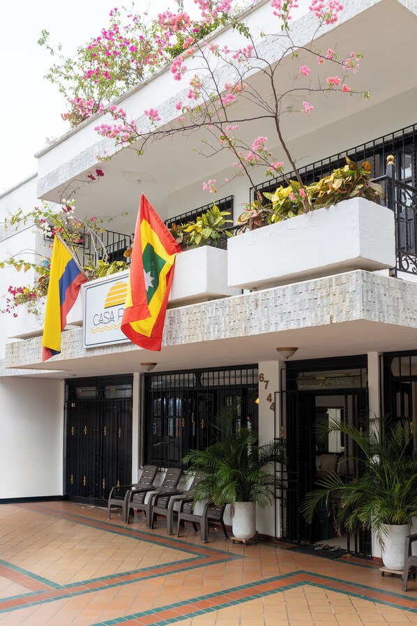 A hotel entrance with a sign reading "CASA PR", outdoor seating, and potted plants. - Hotel Boutique Casa Pere (Cartagena)