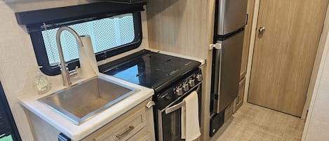 Enjoy cooking in this kitchenette with a stove, sink, microwave, oven, and refrigerator.