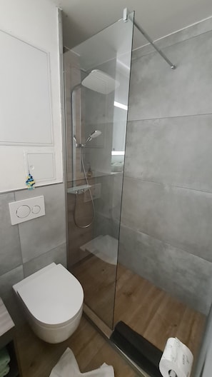 Een douche, een haardroger, handdoeken, toiletpapier