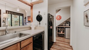 A modern kitchen with a dishwasher, refrigerator, and wooden flooring. - Condo 91sw With a River View and Close to Community Amenities (Deming)