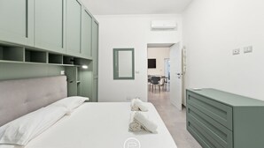 A modern bedroom with a bed, a green dresser, and a mirror. - Alguerìta Apartment - Alghero (Alghero)