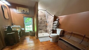Ein Badezimmer mit Holzboden, einer Badewanne, einer Toilette und einem Waschbecken.