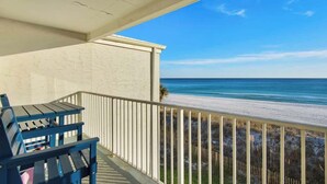 A balcony with a view of the beach and ocean.