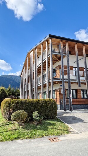 A modern multi-story building with a wooden facade and balconies. - Residence Alpin TOP 3 - Kaprun Incl Summer Card (Kaprun)