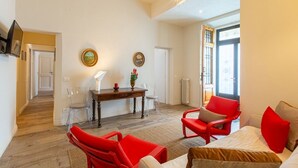Ein Zimmer mit Esstisch, Stühlen, einer Couch und einem Bett.