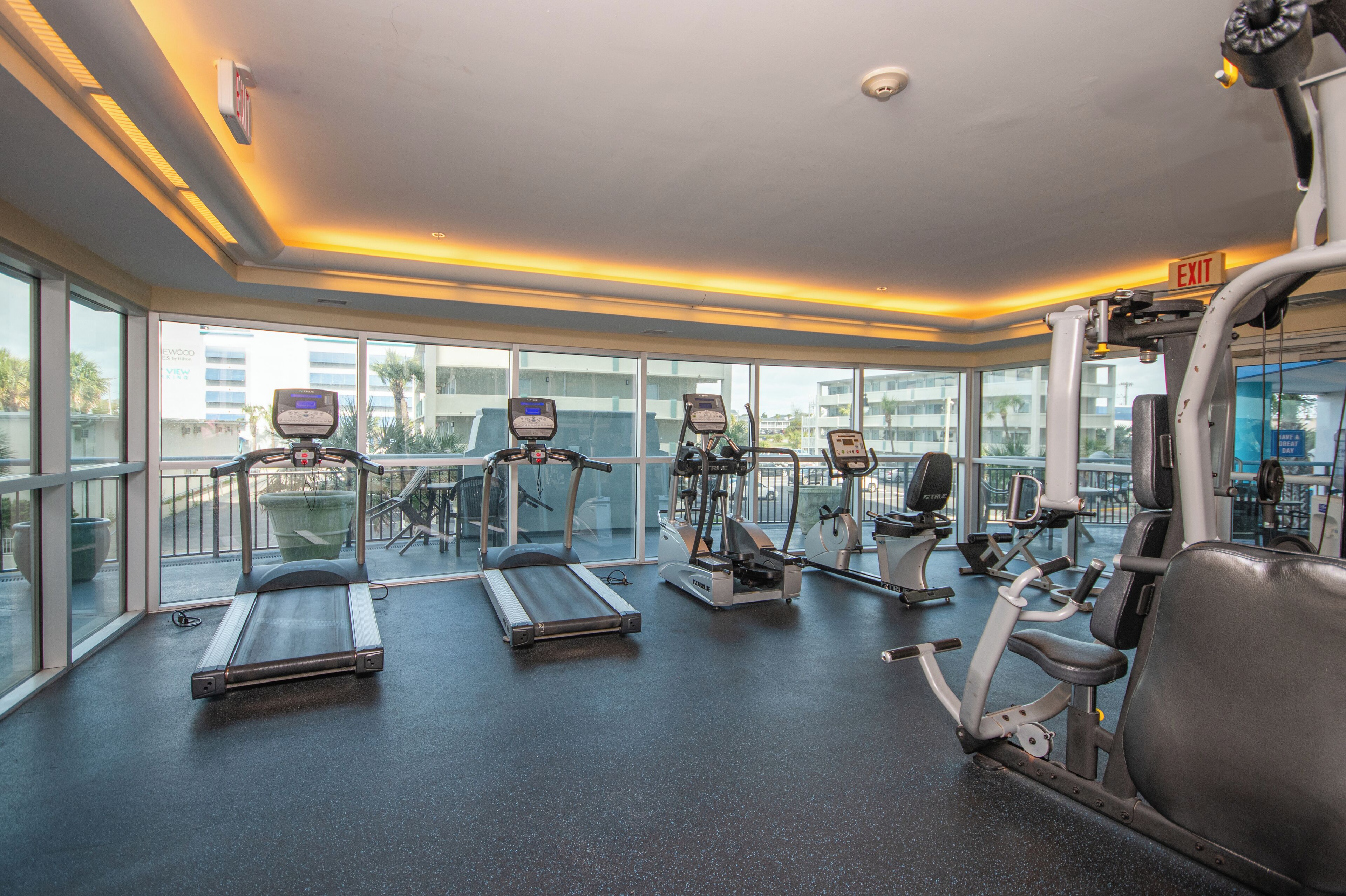 Une salle de sport équipée de tapis de course, de vélos elliptiques et d'appareils de musculation.
