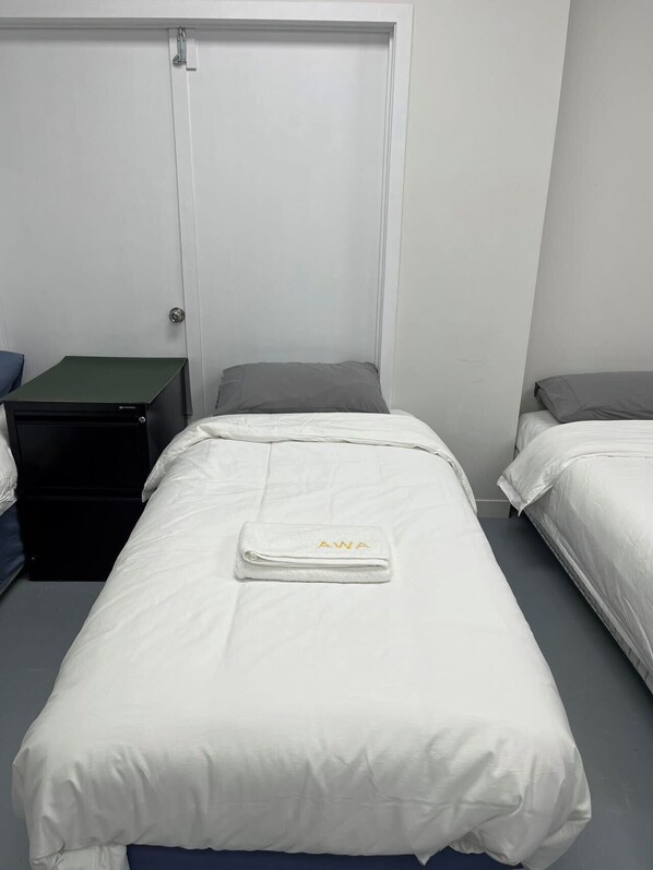 Un dormitorio con dos camas, un escritorio y una puerta.