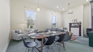 Un salón comedor espacioso con ventanas amplias, chimenea y ventilador de techo.