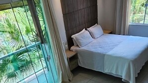 A bedroom with a large bed, a glass-enclosed balcony, and a hot tub. - Pousada Exclusive (Florianopolis)