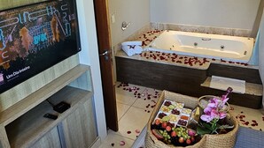 A modern bathroom with a bathtub, a shower area, and a vanity. - Pousada Exclusive (Florianopolis)