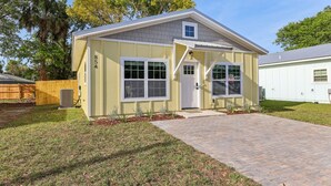 Ein eingeschossiges Haus mit Veranda, Garage und kleinem Garten mit gepflasterter Auffahrt.