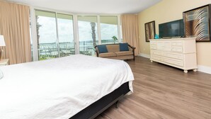 Ein Hotelzimmer mit einem großen Bett, einem Schlafsofa, einem Fernseher und einem Schminktisch.