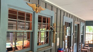 A rustic wooden building with multiple windows, a wooden ceiling, and a large wooden beam.