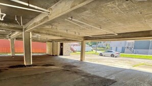 An underground parking garage with concrete pillars and a wet floor.