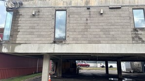A multi-story parking garage with concrete walls and a tiled floor.