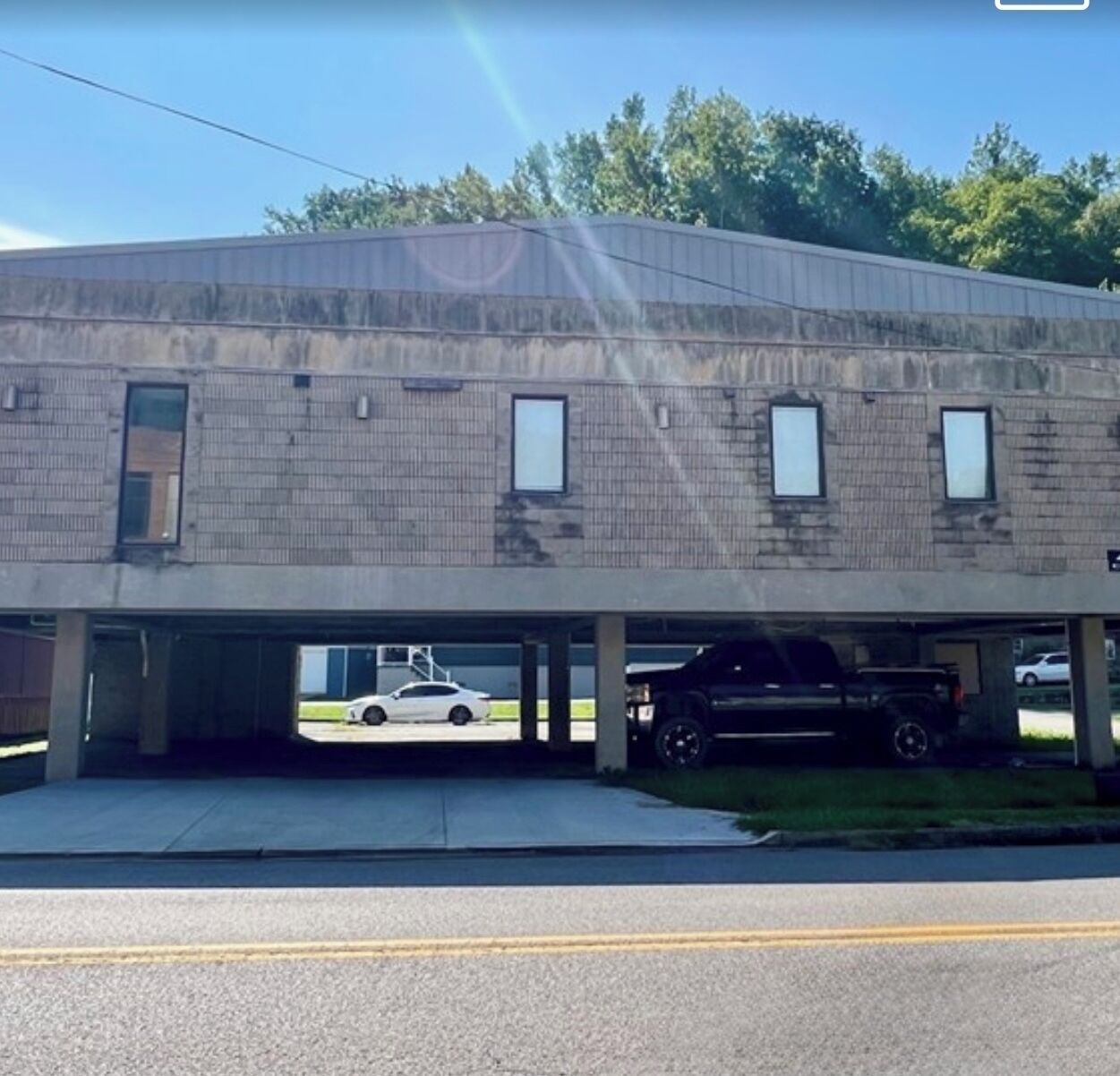 A two-story building with a flat roof and a parking garage.
