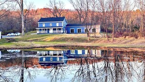 A two-story house with a porch and a pond in front. - Private Heated Indoor Pool + No Neighbors + Ski Shawnee/Camelback (East Stroudsburg)