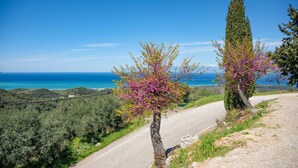 A coastal road with a view of the sea and hills. - Corfu Hillside Villa – Terrace, Nature Walks, Sea Views (Agios Martinos)