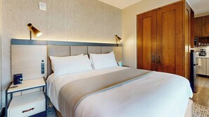 A hotel room with a large bed, bedside tables, a wooden wardrobe, and a kitchenette. - 1BR ski-in/out condo at Westin Riverfront with valley views. (Avon)