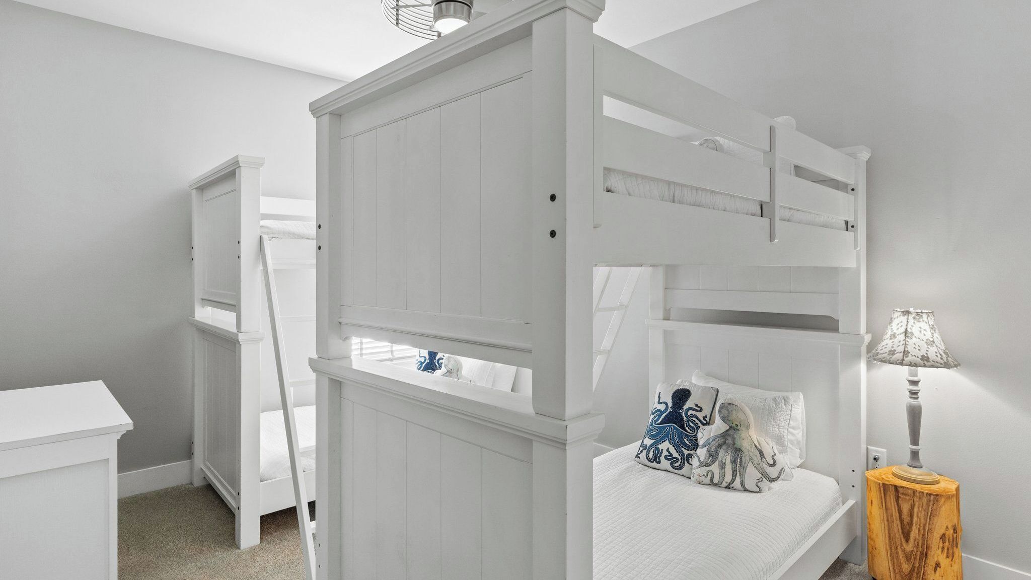 Een stapelbed met een ladder, een nachtkastje en een lamp.