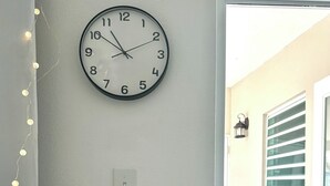 A wall-mounted clock, a light switch, and a small potted plant. - Startfish #2 Apartment 9 Min to Airport FREE WI-FI (CAROLINA)