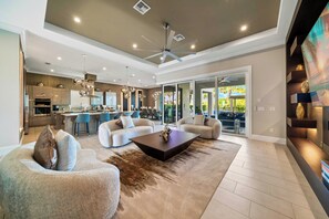 A spacious living area with a modern kitchen, a dining area, and a large sliding glass door leading to a balcony.