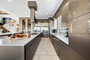 A modern kitchen with a central island, stainless steel appliances, and a sleek design.