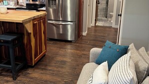 A modern kitchen with wooden cabinets, stainless steel appliances, and a wooden island. - Welcome to Jackson Hole A Charming 1-bedroom house in Historic Mineola. (Mineola)