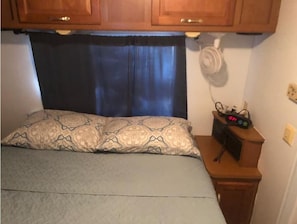 Cozy retreat with a single bed, wooden cabinet, and nightstand.