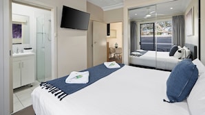 A hotel room with a bed, a TV, a bathroom, and a balcony with a view. - Prickly Pear Stays in Mayfield West (Mayfield West)