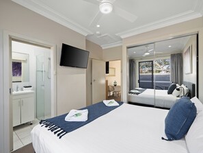 A hotel room with a bed, a TV, a bathroom, and a balcony with a view. - Prickly Pear Stays in Mayfield West (Mayfield West)
