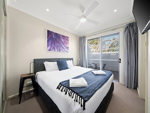 A hotel room with a bed, a ceiling fan, a window with curtains, and a painting on the wall. - Prickly Pear Stays in Mayfield West (Mayfield West)