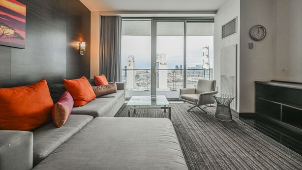 A modern hotel room with a large window, a sofa set, a coffee table, and a chair. - Strip View Studio • Balcony • No Resort Fee • Free Parking • TE25 (Las Vegas)
