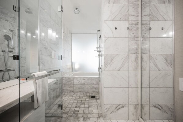 A modern bathroom with a glass-enclosed shower, a bathtub, and a vanity with a towel. - Strip View Studio • Balcony • No Resort Fee • Free Parking • TE25 (Las Vegas)